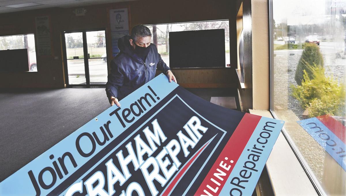 Graham Auto Repair Owner Troy Vaninetti hanging the "Join Our Team" sign in the window of our new Yelm Shop. Yelm, WA 98597